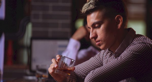 hombre mirando a un vaso preguntándose cómo conseguir novia