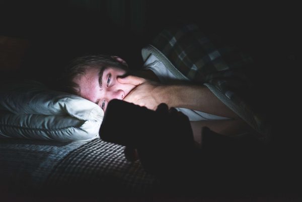 hombre mirando en su móvil frases para ligar con chicas