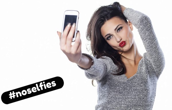chica poninendo morritos y haciéndose un selfie para ligar online