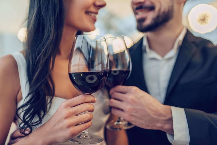 pareja durante su primera cita brindando con una copa de vino