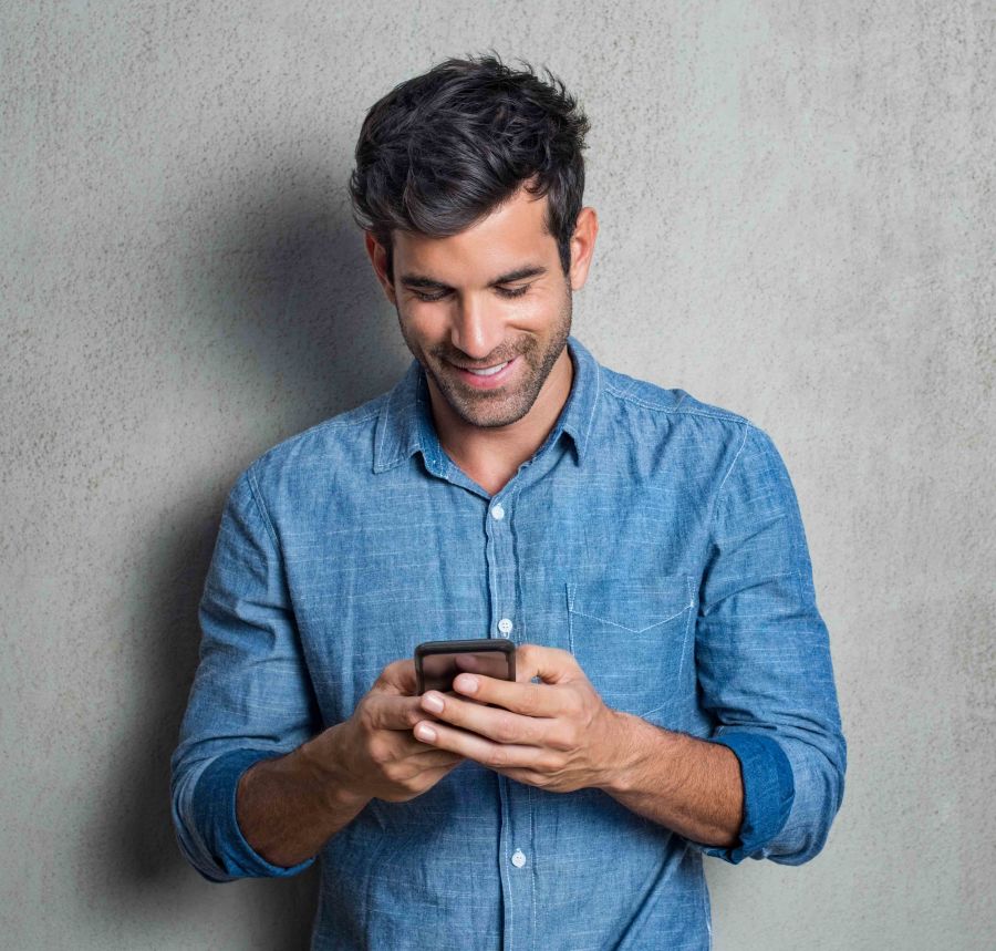 hombre sonriente consulta app para buscar pareja